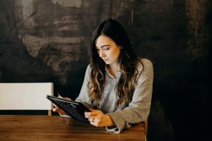 mujer con saco en oficina revisando la computadora