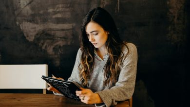 mujer con saco en oficina revisando la computadora