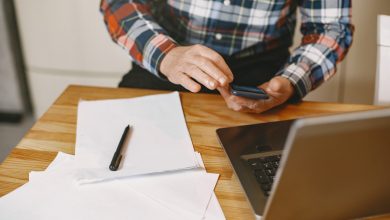 Hombre revisando en el celular fechas de corte y de pago y tomando nota
